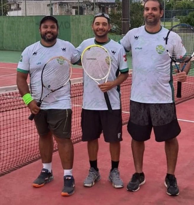 Rafael e dois jogadores de camiseta da equipe junto à rede de uma quadra rápida